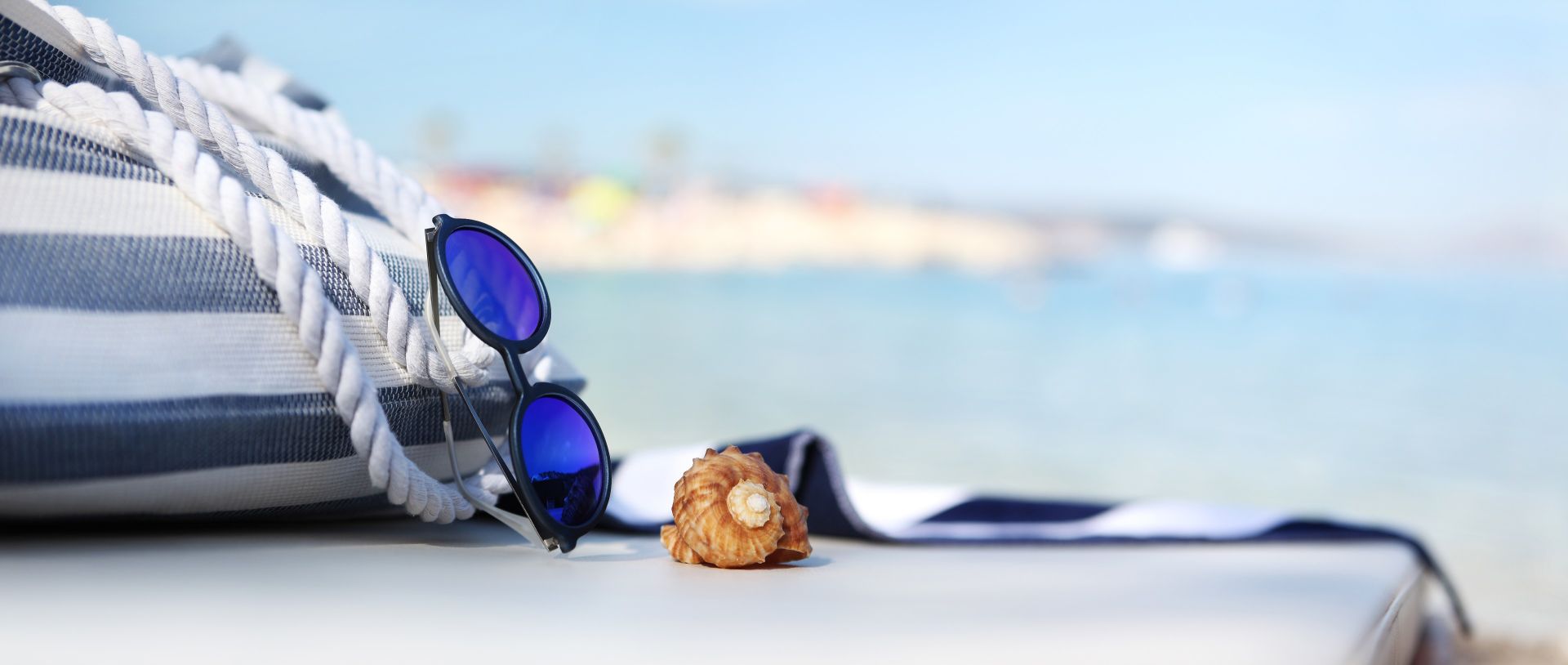 a close up of beach equipment, a rope, sunglasses, a floating device and seashell